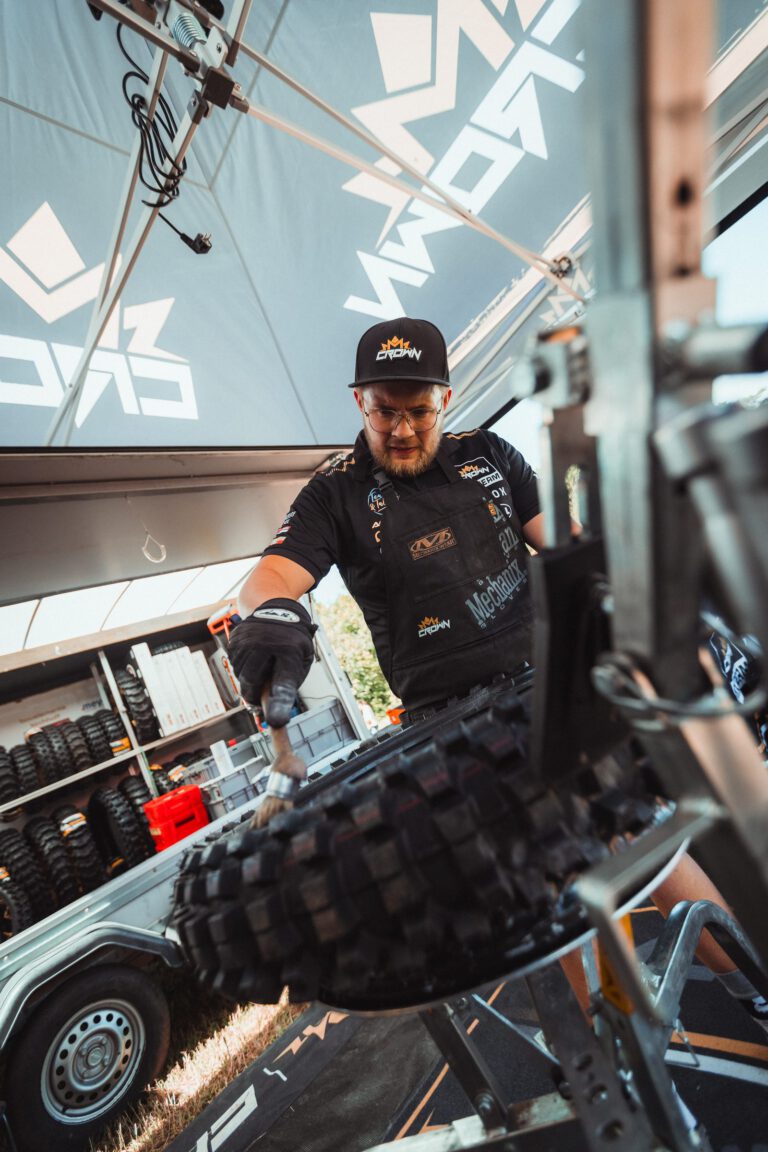 Ein Crown-MX-Mechaniker wechselt im Fahrerlager einen Reifen
