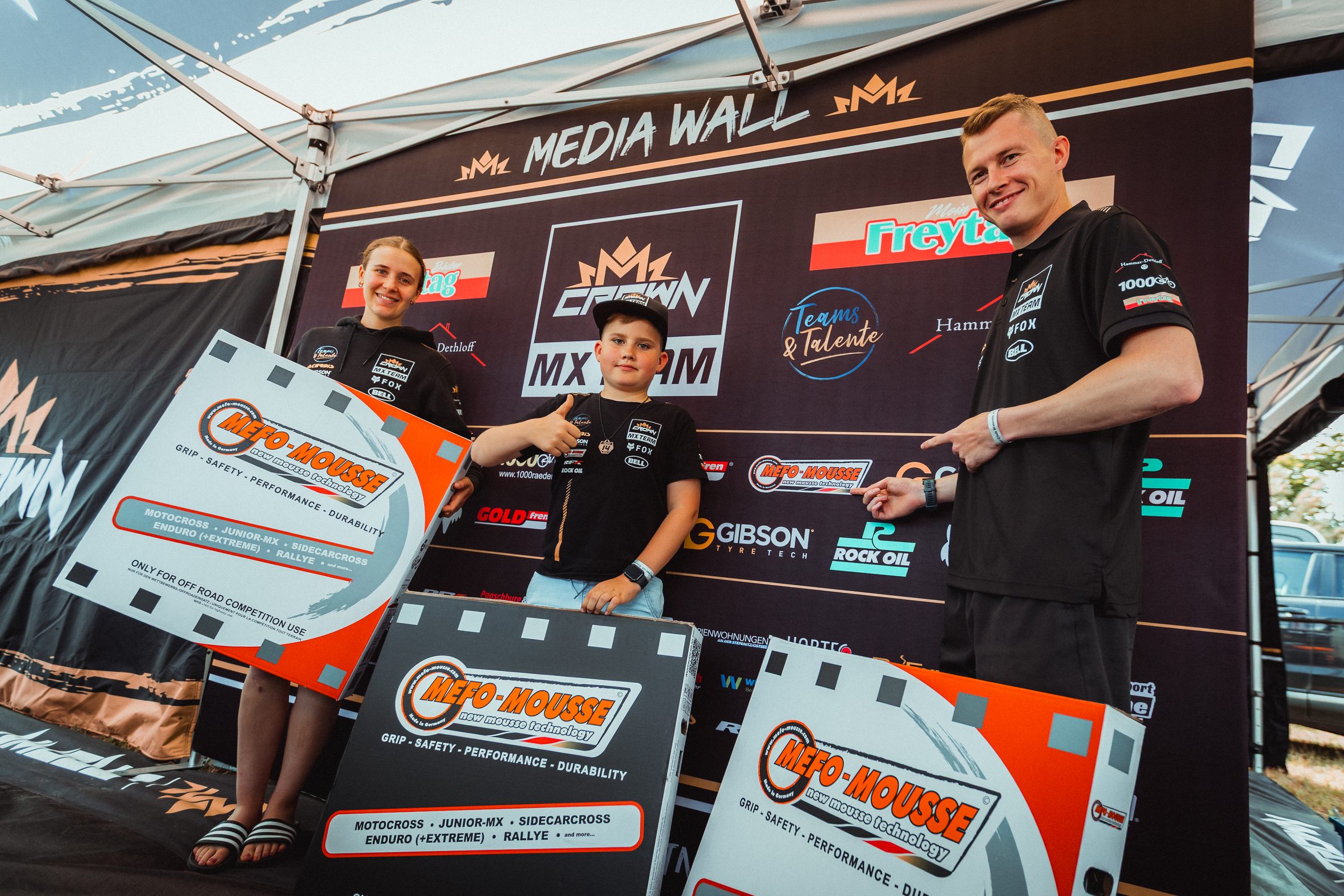 Das Crown-MX-Zelt mit Media Wall und Partnerlogos im Fahrerlager